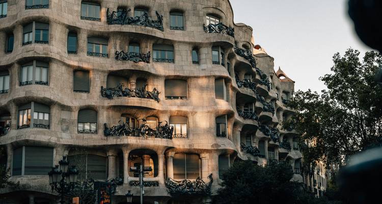 Vue complète de la rue de la Casa Milà de Gaudí baignée dans la lumière chaude du soir