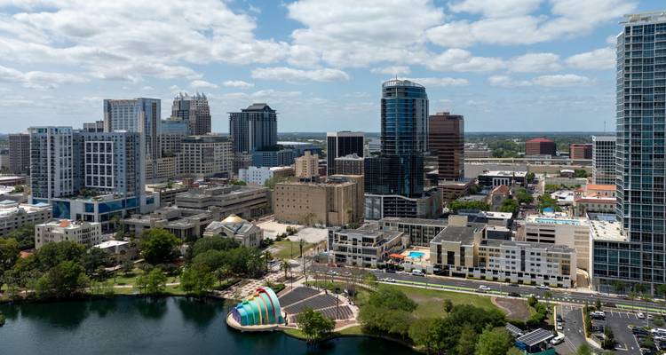 Vue aérienne de la ligne d'horizon du centre-ville d'Orlando et du lac Eola sous un ciel partiellement nuageux