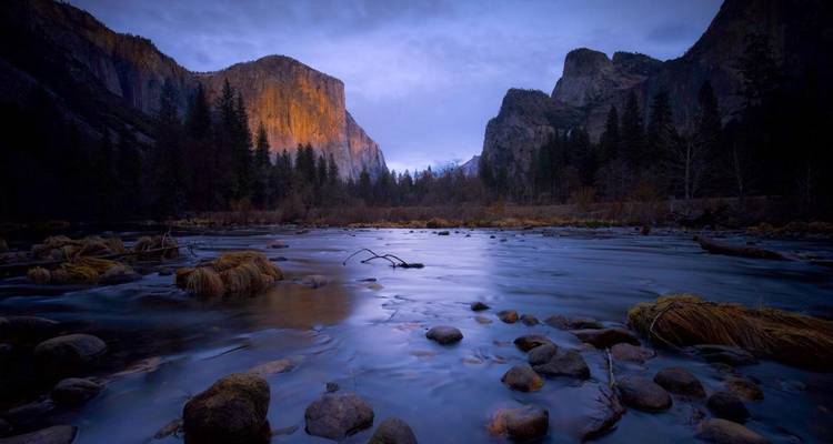 Vue crépusculaire de la vallée de Yosemite reflétée dans une rivière tranquille avec une lumière bleue déclinante.
