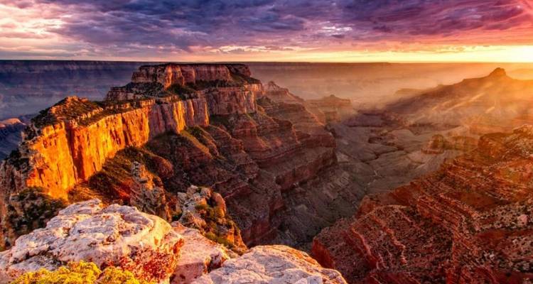 Un coucher de soleil flamboyant illuminant les falaises et les crêtes accidentées du Grand Canyon avec des couleurs éclatantes.