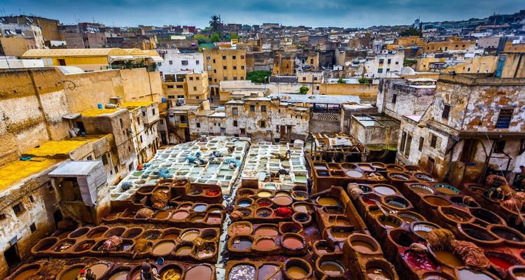 Kleurrijke verfkuipen vullen de beroemde leerlooierij temidden van de oude gebouwen van de historische medina.