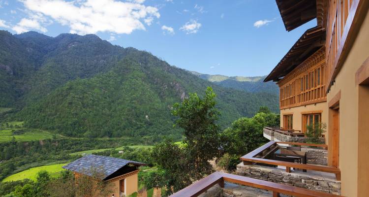Luxuriöse Lodge-Balkone blicken auf üppig grüne Berge und Reisterrassen unter einem strahlend blauen Himmel.