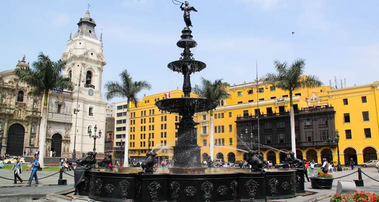 Ornate fountain surrounded by colonial facades and palm trees in Lima’s Plaza de Armas.