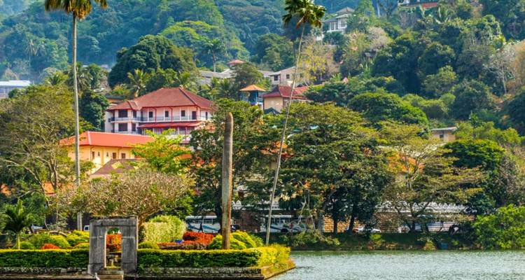 Les bâtiments colorés de la ville et la verdure encadrés par le lac de Kandy pendant la journée.