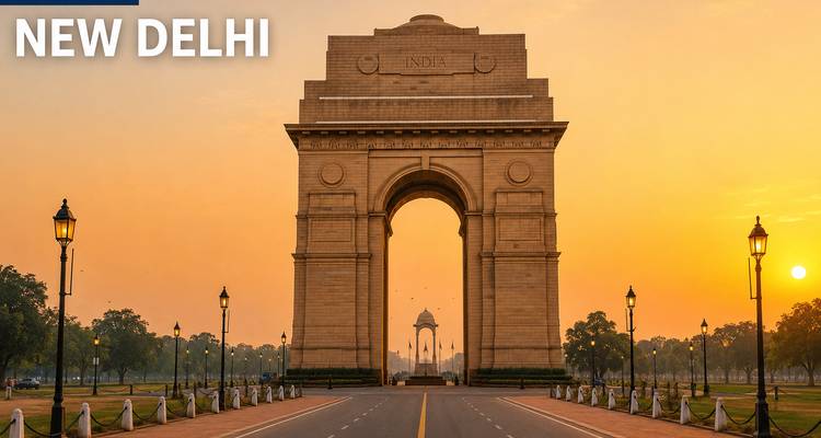 Das India Gate Denkmal, gerahmt von einem Sonnenaufgangshimmel und flankiert von Laternenmasten auf einer verlassenen Allee.