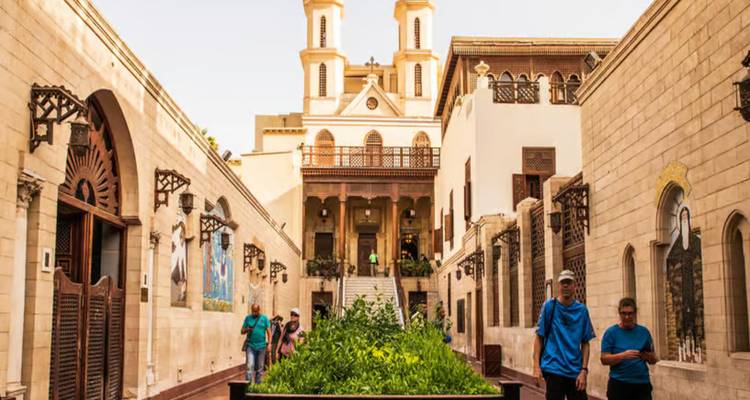 Los visitantes caminan por una calle histórica de piedra caliza hacia la Iglesia de los Santos Sergio y Baco en El Cairo.