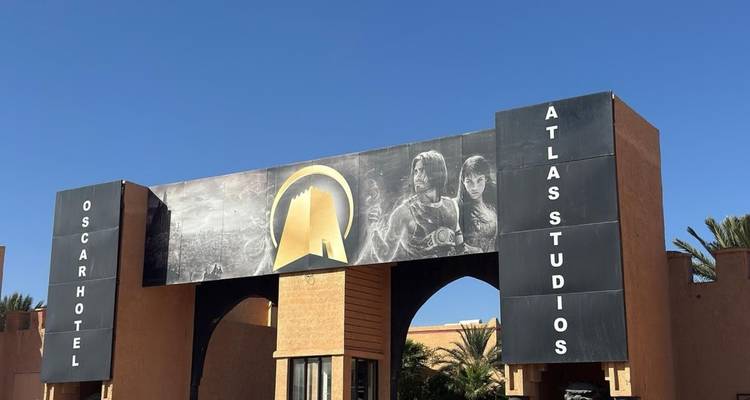 Ingangspoort van Oscar Hotel Atlas Studios onder een strakblauwe hemel.