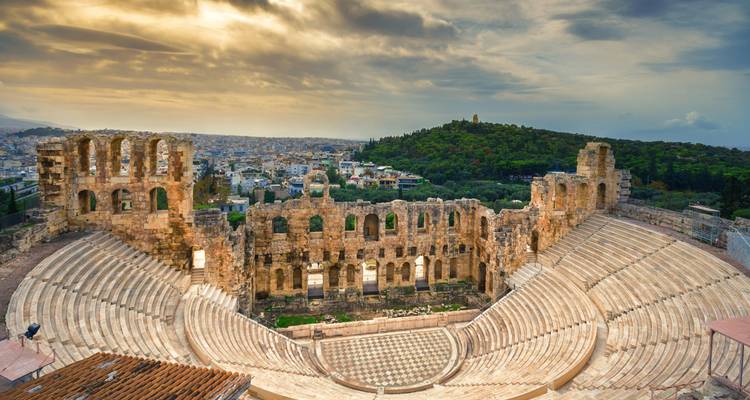 Ancient stone theatre of Herodes Atticus overlooking Athens beneath a dramatic sky