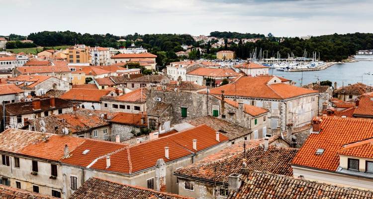 Uitzicht vanaf het dak van historische Kroatische kustplaats met jachthaven op de achtergrond onder bewolkte hemel