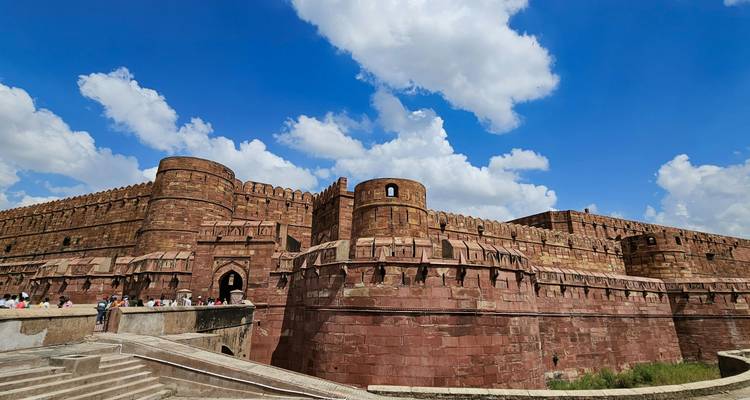 De kolossale rode zandstenen muren en bastions van Agra Fort rijzen op tegen een levendige lucht bezaaid met toeristen.
