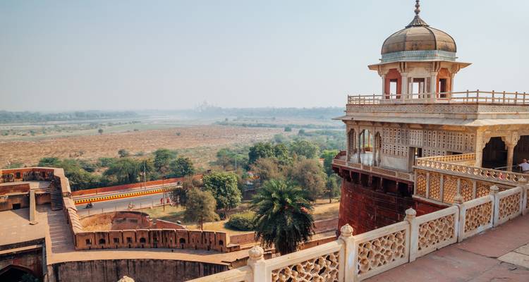 Een mistig uitzicht over de Yamuna-vlakte vanaf de vestingwerken van Agra Fort met een eenzaam paviljoen op de voorgrond.