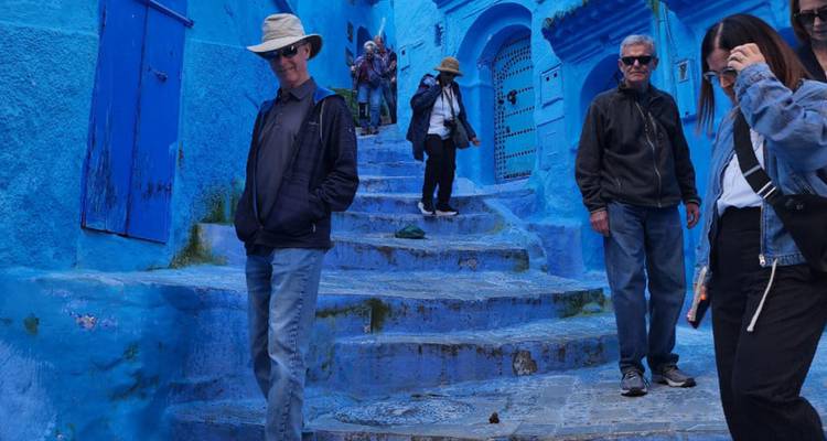 Les visiteurs descendent un escalier étroit aux murs bleu lavé entre des murs d'un indigo éclatant à Chefchaouen.
