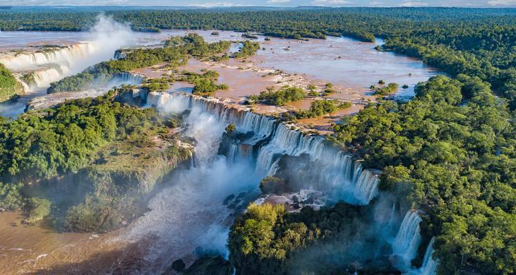 Luftaufnahme des umfangreichen Iguazu-Wasserfallsystems, umgeben von dichtem Regenwald.