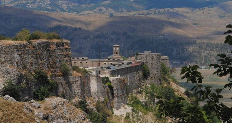 Los muros de piedra y torres de la Fortaleza de Gjirokastra se alzan en una cresta que domina amplios valles.