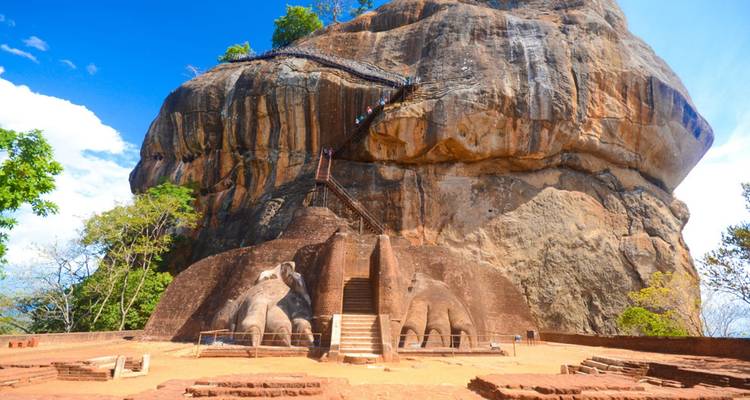 Toeristen die de steile trappen beklimmen bij de leeuwenpoot-ingang van de Sigiriya-rotsformatie.