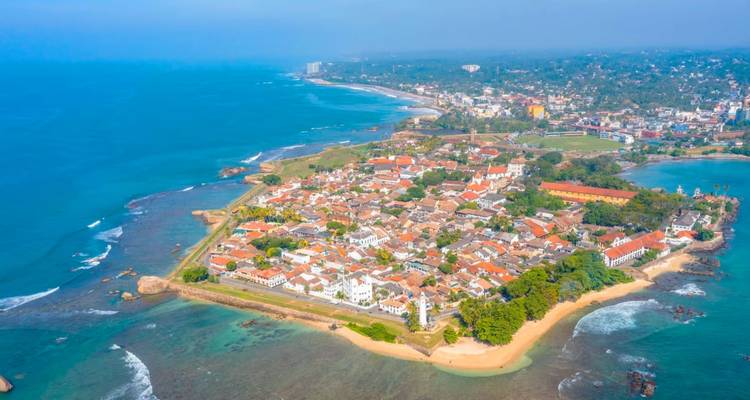 Kristalhelder luchtfoto van het schiereiland Galle Fort omgeven door levendig blauwe zee en rifvlaktes.