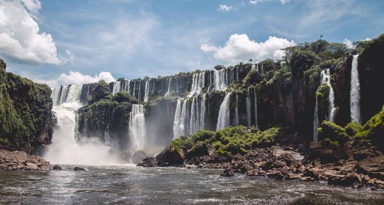 Vue panoramique des chutes d'Iguazu se jetant des falaises dans les eaux turbulentes en contrebas.