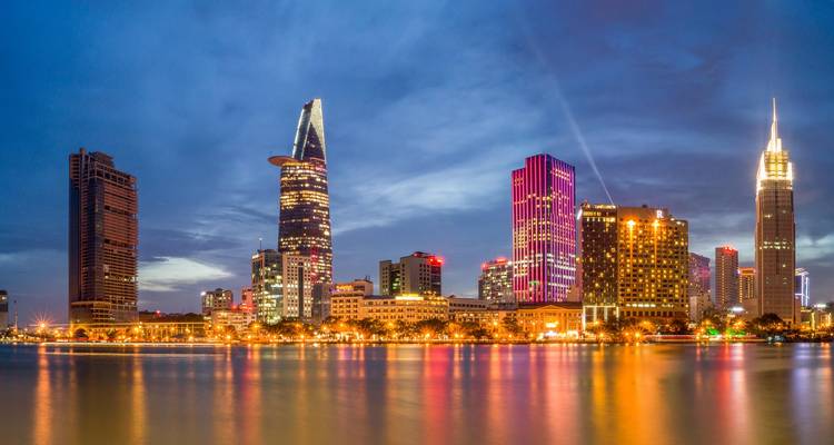 Panorama nocturne de la ligne d'horizon de Ho Chi Minh-Ville avec les lumières colorées des tours se reflétant sur le fleuve
