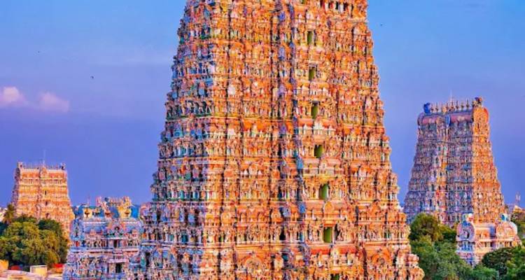 Vibrantly painted gopuram of a South Indian temple rising against a clear blue sky.