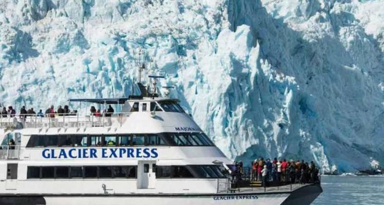 Le bateau d'excursion Glacier Express navigue le long d'une paroi imposante de glace bleue de glacier.