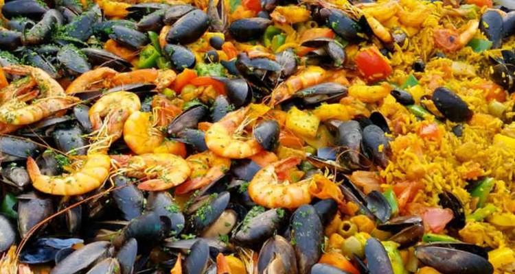 Colorful paella heaped with shrimp, mussels, peppers and saffron rice.