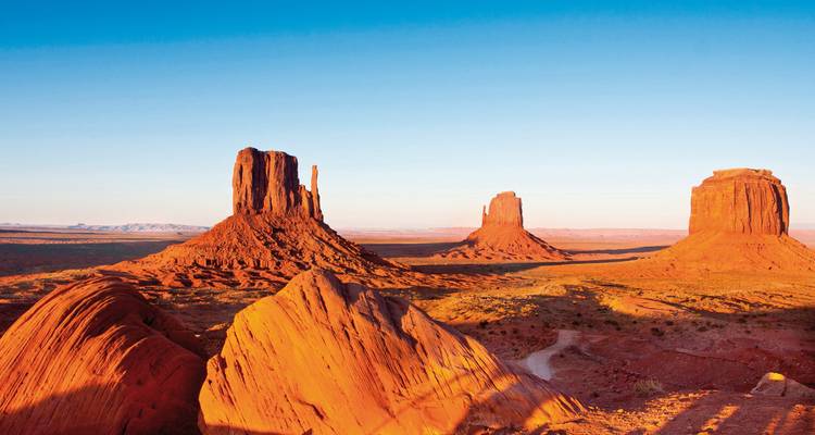 Ikonische rote Sandsteintafelberge des Monument Valley, die im Licht der späten Tageszeit leuchten