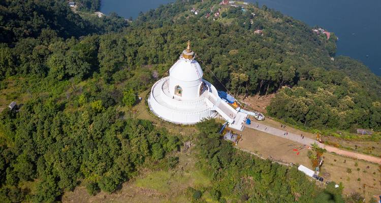 Vista aérea de la blanca Pagoda de la Paz Mundial anidada en el bosque muy por encima del Lago Phewa.