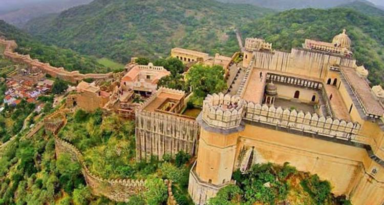Luftaufnahme der Mauern der Kumbhalgarh-Festung, die sich über grüne Hügel und den Palastkomplex schlängeln.