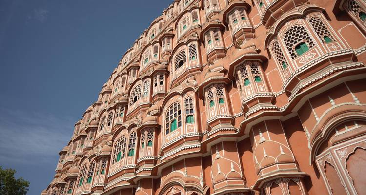 Façade remarquable du Hawa Mahal rose de Jaipur sur un ciel bleu dégagé.