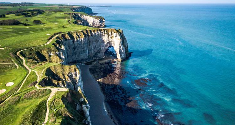 Vue aérienne de la côte d'Étretat avec ses falaises majestueuses et les eaux turquoise de l'Atlantique.