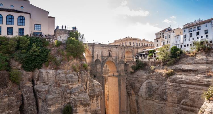 Klare Tageslichtsicht der Puente Nuevo Bruecke und der umliegenden weiß getünchten Gebäude, die auf zerklüfteten Klippen thronen.