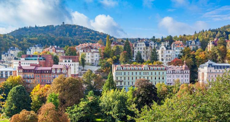 Vista elevada de los elegantes edificios multicolores de Karlovy Vary acurrucados en las laderas boscosas durante el otoño.