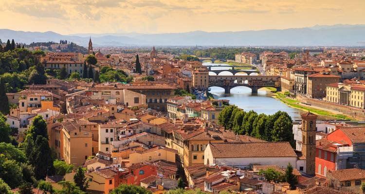 Uitgebreid panoramisch uitzicht over Florence met de Arno rivier die onder de Ponte Vecchio stroomt en terracotta dakpannen die zich uitstrekken naar de verre Toscaanse heuvels.
