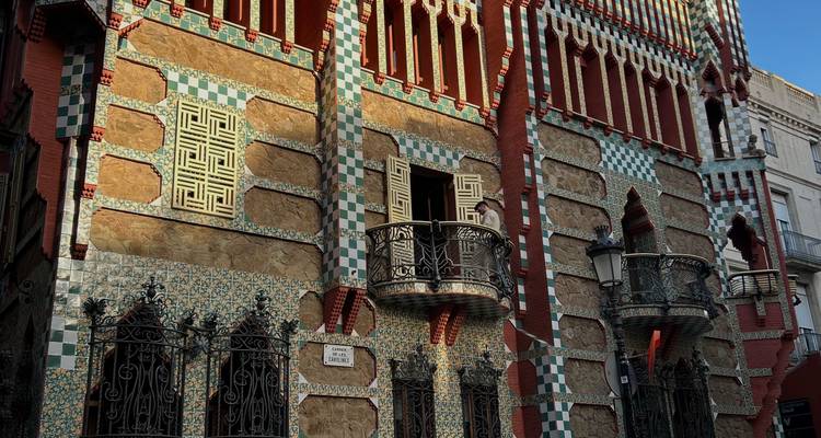 Facade en brique et carrelage aux motifs colorés de la Casa Vicens dotée de balcons en fer forgé à la lumière chaude de l'après-midi.