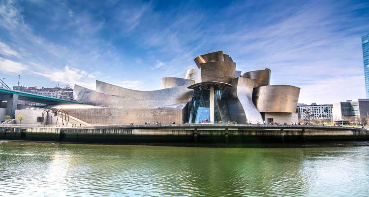 Panorama diurne des courbes scintillantes en titane du Musée Guggenheim Bilbao situé en bordure du fleuve