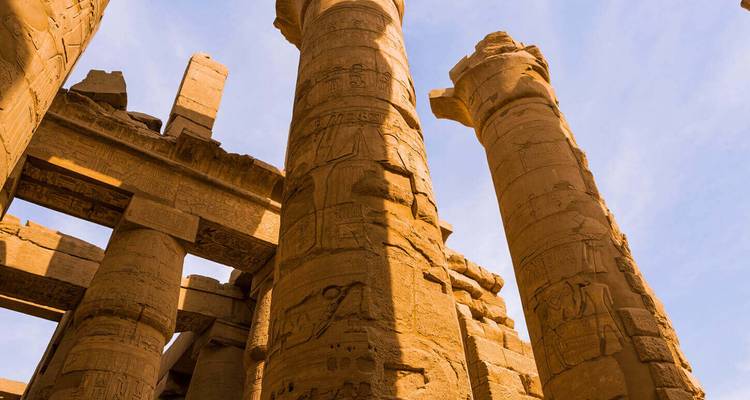 Les colonnes de pierre ensoleillées du temple de Karnak, couvertes de hiéroglyphiques, s'élèvent vers le ciel.
