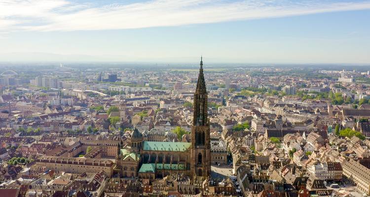 Sweeping aerial of Strasbourg showing the towering Gothic cathedral rising above a dense historic city.