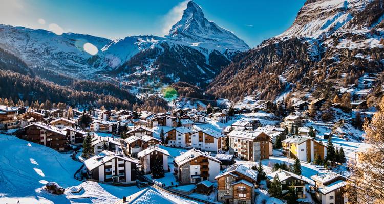 Sneeuwbedekt dorpje Zermatt genesteld onder het iconische Matterhorn onder helder winterlicht.