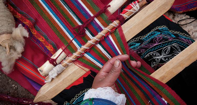 Close-up of intricate Andean weaving on a traditional wooden loom
