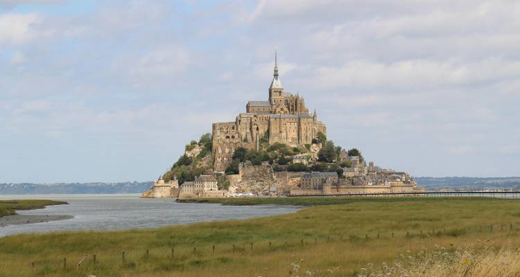 Iconic tidal island of Mont Saint-Michel rising above the sands and tidal flats.