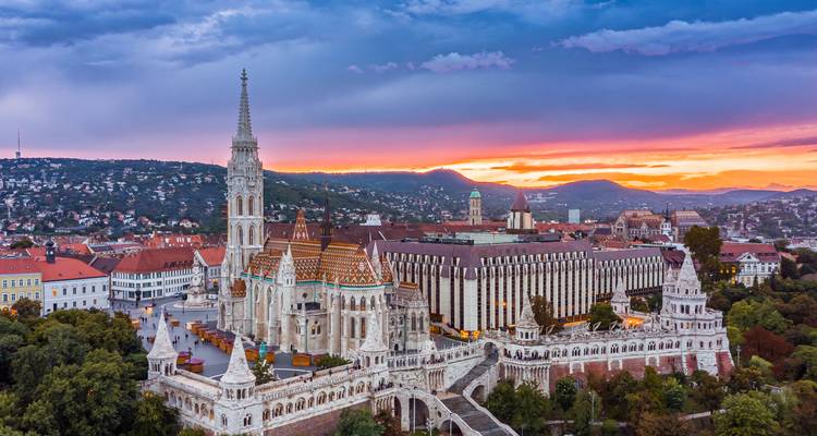 Fairytale Fisherman's Bastion and Matthias Church glow at sunrise above the Danube in Budapest.