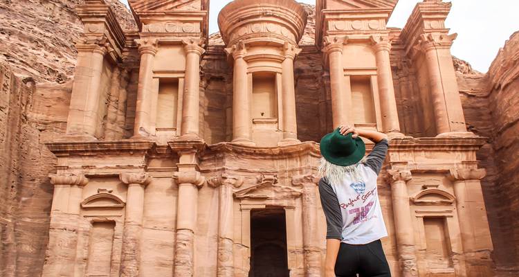 Traveler admires the grand façade of the Monastery at Petra.