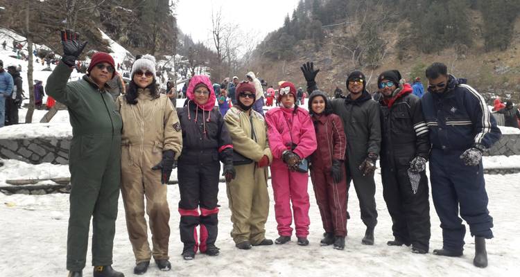 Bundled-up travellers posing together on a snowy mountainside.