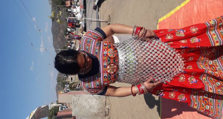Woman trying on colourful traditional Indian attire in an outdoor market area.