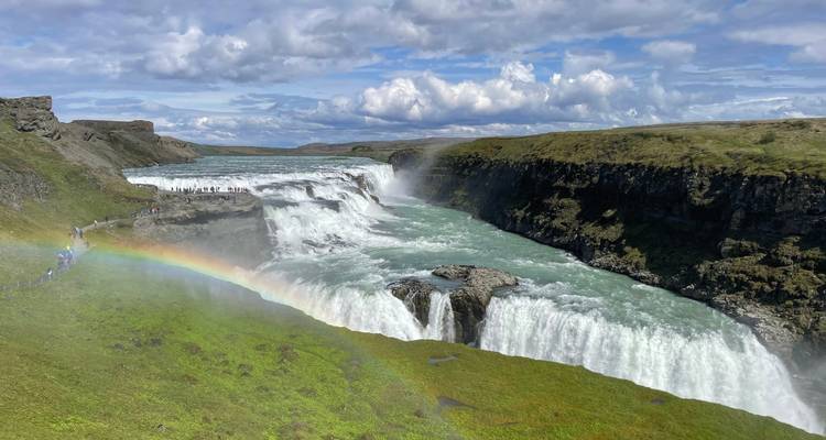La puissante cascade de Gullfoss se précipitant dans un canyon avec un arc-en-ciel brillant.