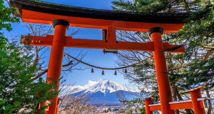 Un portail torii rouge vif encadre le Mont Fuji enneigé sur un ciel bleu et cristallin d'hiver.