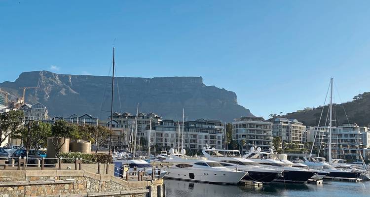 Marina at Cape Town’s V&A Waterfront with yachts and Table Mountain backdrop under clear skies.