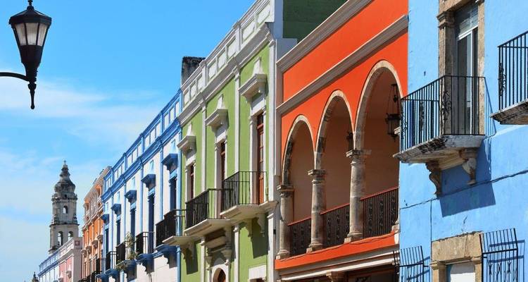 Rij van felgekleurde koloniale gebouwen met bogen en balkons in het historische centrum van Campeche.