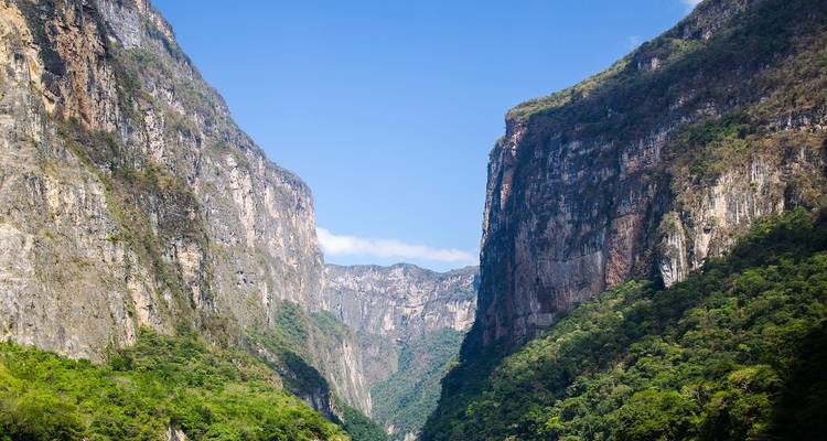 Steile verticale canyonwanden met weelderige begroeiing rijzen uit boven de Grijalva River in Sumidero Canyon.