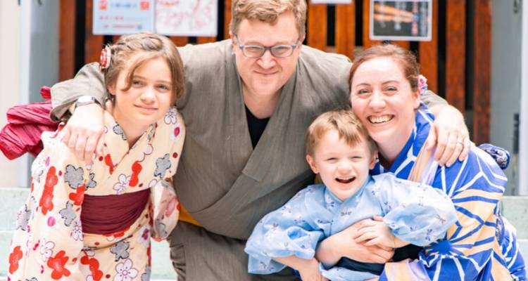 Smiling family dressed in colourful yukata posing together at a cultural workshop.